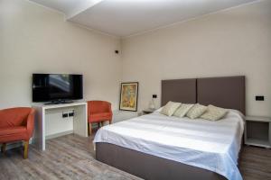 a bedroom with a bed and a flat screen tv at Al Ponte Garnì in Pergine Valsugana