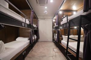 a room with three bunk beds on a bus at Sleep Here Hostel, Melaka in Melaka