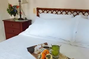 a tray with fruits and drinks on a bed at Hacienda la Romelia 