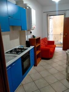 a kitchen with blue cabinets and a red couch at james house green in Teramo