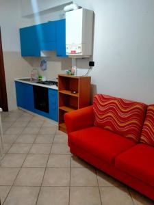 a living room with a red couch and a kitchen at james house green in Teramo