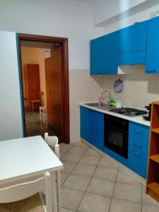 a kitchen with blue cabinets and a white table at james house green in Teramo