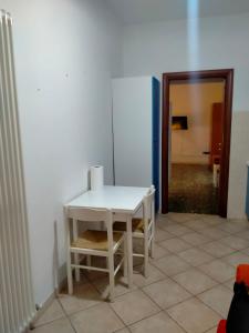 a white table and a chair in a room at james house green in Teramo
