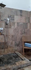 a shower in a bathroom with a stone wall at Bel ombre's Panoramic view in Bel Ombre