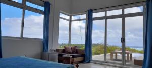 um quarto com uma cama e uma grande janela em Bel ombre's Panoramic view em Bel Ombre