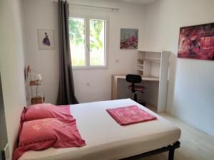 Schlafzimmer mit einem Bett mit rosa Bettwäsche und einem Fenster in der Unterkunft Maison du rieu 8 personnes in Saint-Geniès