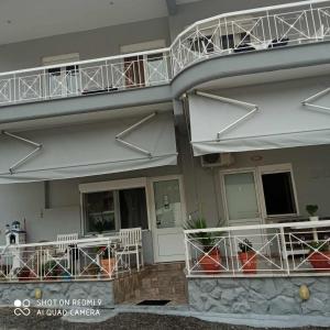 - un balcon avec des tables et des chaises dans l'établissement Guest House Sakis., à Órma