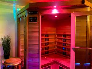 un vestidor con luces moradas y un taburete en Espace détente jacuzzi sauna en Gagny