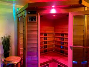 un vestidor con luces moradas y un taburete en Espace détente jacuzzi sauna, en Gagny