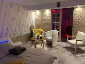 - une chambre avec un lit, une table et des chaises dans l'établissement Espace détente jacuzzi sauna, à Gagny