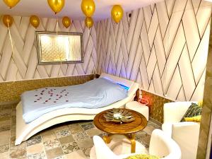 Gagny的住宿－Espace détente jacuzzi sauna，一间设有一张床、一张桌子和气球的房间