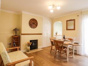 a dining room with a table and a clock on the wall at 46 By The Creek in Faversham