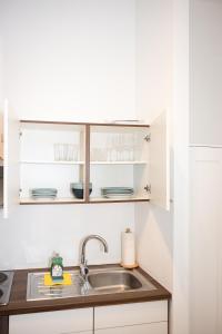 uma cozinha com armários brancos e um lavatório em Premium 80 m2 Apartment - 5 min to Center - Free Parking em Viena