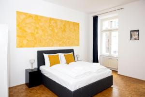 um quarto com uma cama grande e almofadas amarelas em Premium 80 m2 Apartment - 5 min to Center - Free Parking em Viena