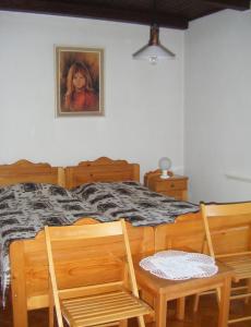 1 dormitorio con 1 cama con 2 sillas y 1 pintura en Guest House Kmetija en Dane