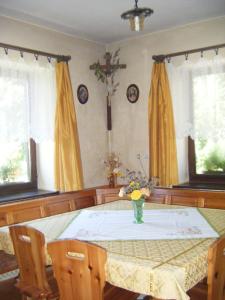 uma mesa de jantar com um vaso de flores em Guest House Kmetija em Dane