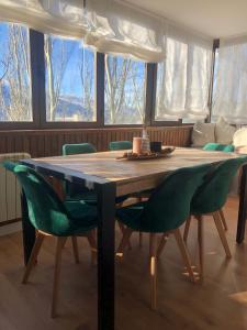 a dining room table with green chairs around it at APTO NUEVO - 2 habitaciones + 2 baños en zona baja in Sierra Nevada