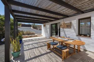 a wooden deck with a wooden table and chairs at Casa Marisa with Heated Pool & Garden in Tindaya