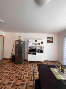 a room with a kitchen with a refrigerator and a table at Casa 10 personas cerca de Bahia Inglesa in Caldera