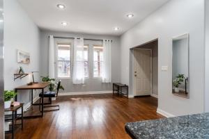 - un salon vide avec parquet et murs blancs dans l'établissement Flexhome Logan Square Duplex 3BR Apt S2 - READ INFO, à Chicago