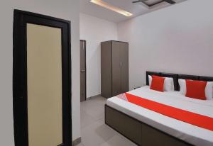 a bedroom with a bed with red pillows on it at Flagship White Solitaire in Ludhiana