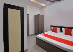 a bedroom with a bed with red pillows at Flagship White Solitaire in Ludhiana