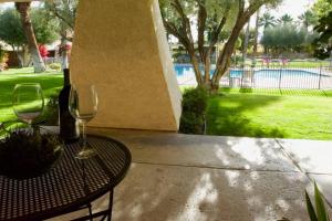 a table with two wine glasses on a patio at Poolside Palm Springs Getaway in Palm Springs