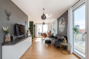 sala de estar con sofá y TV en Apartment mit traumhafter Dachterrasse & Weitblick, en Viena