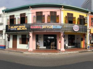 a building on the corner of a street at Sleep Here Hostel, Melaka in Malacca