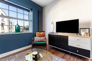 a living room with a tv and a large window at Beautiful Aldgate Apartment in London