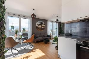 cocina y sala de estar con sofá y mesa en Apartment mit traumhafter Dachterrasse & Weitblick en Viena