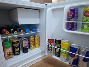 an open refrigerator filled with lots of cans and drinks at Ergi's Host Apartment in Krujë