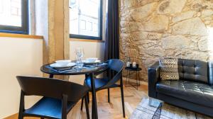 een eetkamer met een tafel en stoelen en een bank bij Premium Duplex in Bonfim by LovelyStay in Porto