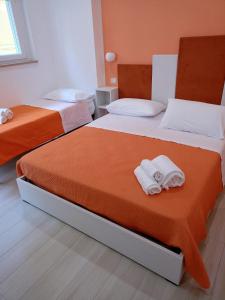 two beds in a room with towels on them at Mary's rooms in Parghelia