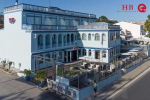 una mujer parada frente a un edificio azul en Urban Hotel Santa Eulalia, en Albufeira