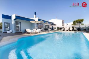 a swimming pool in front of a villa at Urban Hotel Santa Eulalia in Albufeira