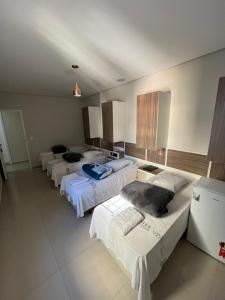 a row of beds in a large room at Hotel Quintino in Sao Paulo