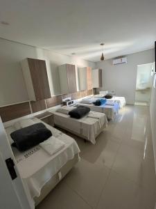 a hospital room with three beds in it at Hotel Quintino - Metrô Sé -localizado no coração de São Paulo Próximo 10 minutos do Brás 5 minutos da 25 de Março e com estacionamento no local grátis in Sao Paulo