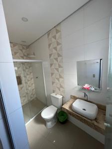 a bathroom with a toilet and a sink and a shower at Hotel Quintino in Sao Paulo