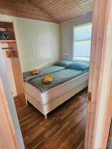 Cama en habitación pequeña con ventana en Lakeside cabin in Thingvellir, en Úlfljótsvatn