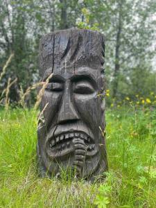 a statue of a head in a field of grass at Lakeside cabin in Thingvellir in Úlfljótsvatn