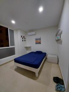 a bedroom with a blue bed and a window at Oasis Suite Salinas in Salinas