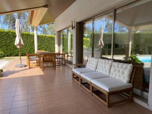 een woonkamer met een bank op een patio bij Casa do Lago, Privacidade e Beleza Natural in Esposende
