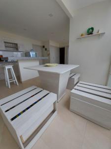 a white kitchen with two beds and a counter at Oasis Suite Salinas in Salinas