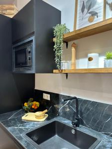 Bear Homes - Olimpia Suite في فالنسيا: طاولة مطبخ مع حوض وميكروويف