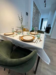 Bear Homes - Olimpia Suite في فالنسيا: طاولة طعام عليها صحون واكواب