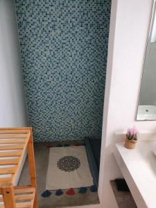 a small bathroom with a shower with blue tiles at Cute holiday apartment in the heart of Grand Bay in Grand-Baie