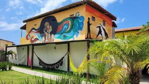 un edificio con una pintura a un lado. en Flat - Condomínio Fechado - Frente Mar en Vera Cruz de Itaparica