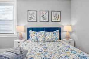um quarto com uma cama azul e três fotografias na parede em BRAND NEW, Private Parking, Stylish 3bedroom house em Pittsburgh