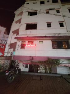 un edificio blanco con una motocicleta estacionada frente a él en JAI MALHAR LODGE en Pune